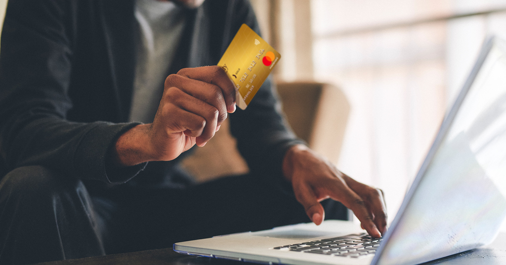 man uses credit card to shop online