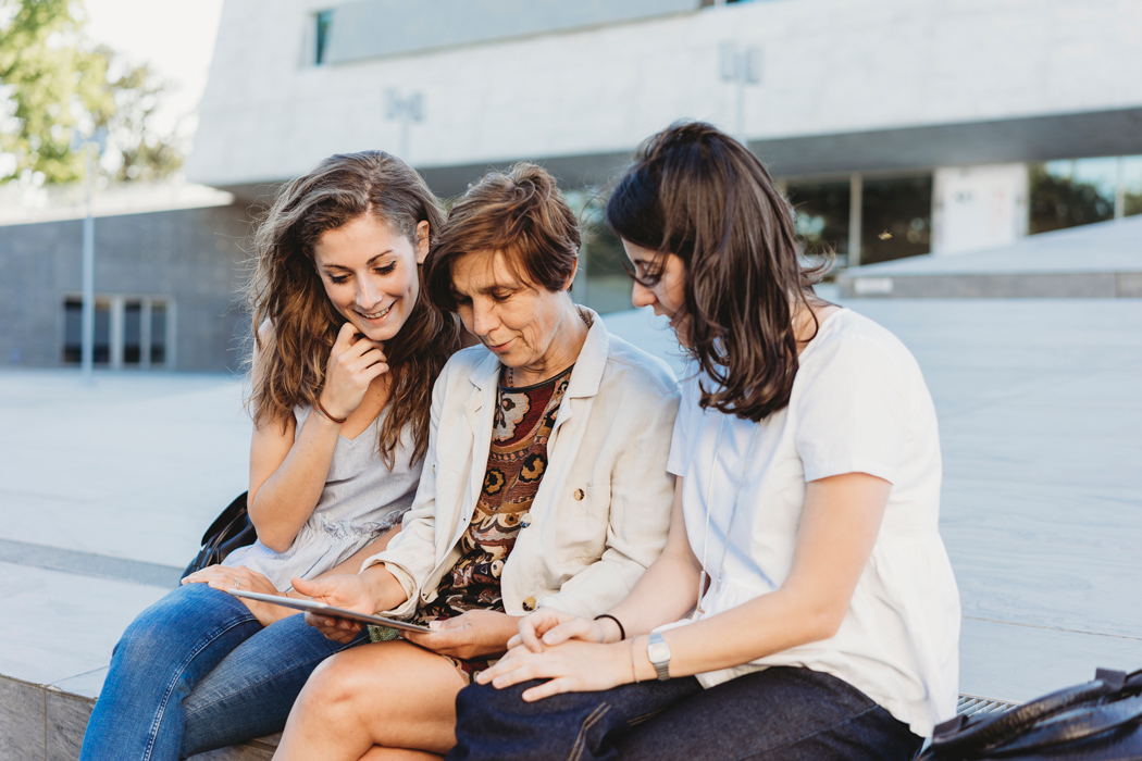 mother sits with daughters on campus