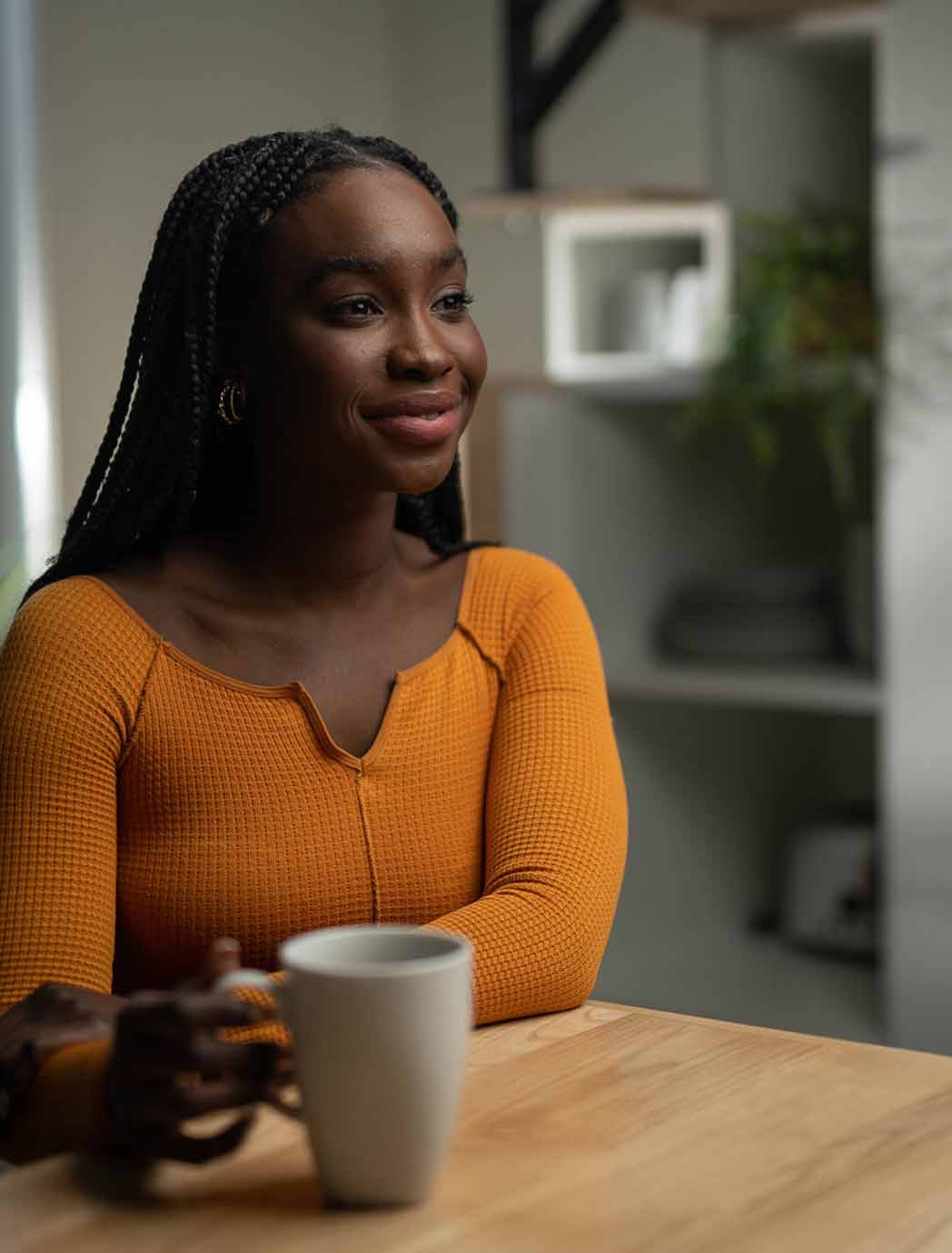 young woman with coffee in kitchen